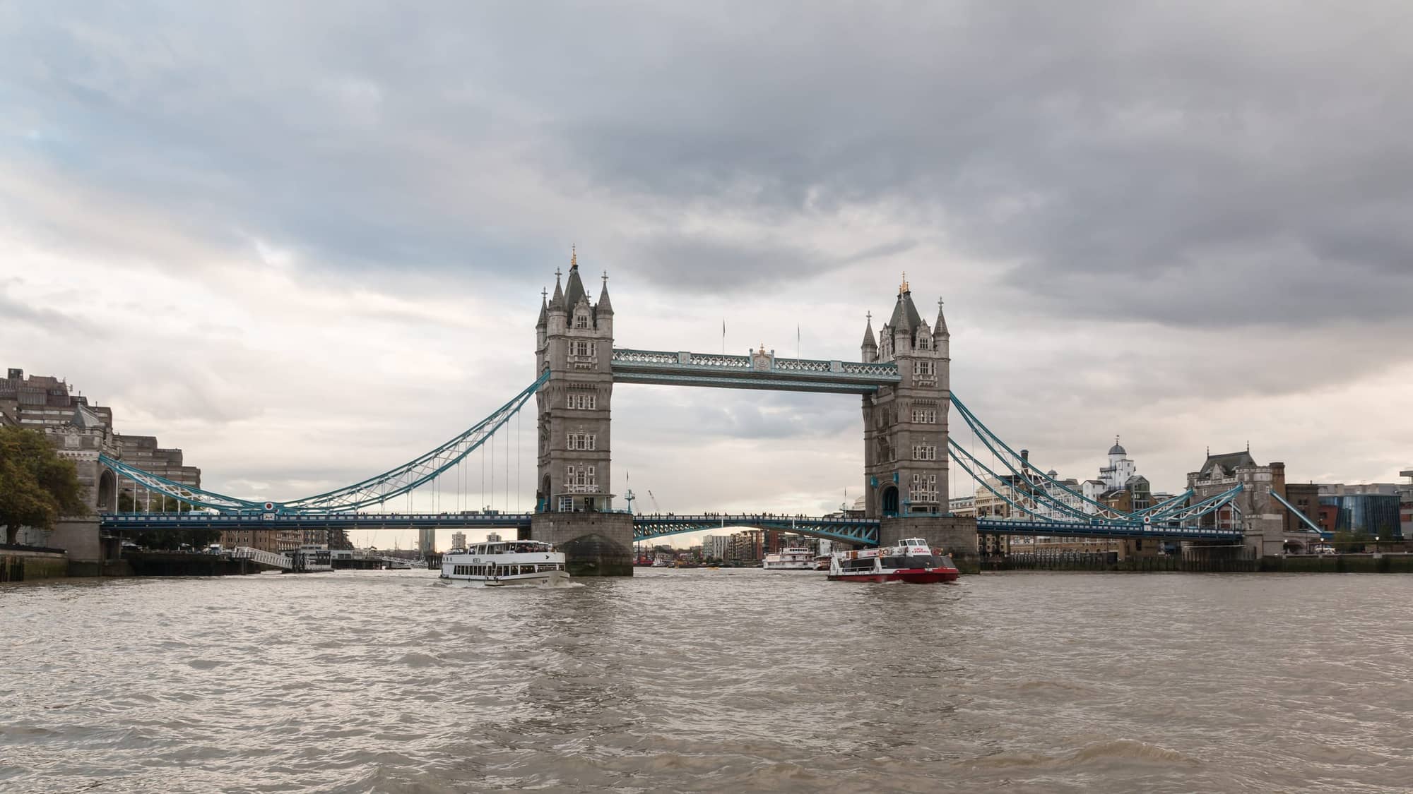 Tower Bridge crossing the River Thames in London under a cloudy sky